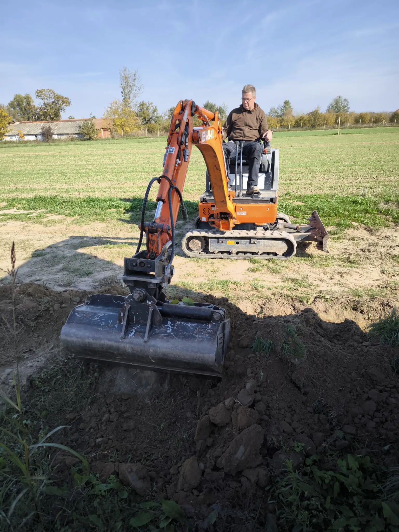 Mini bager kopa iskop u otvorenom polju po sunčanom danu