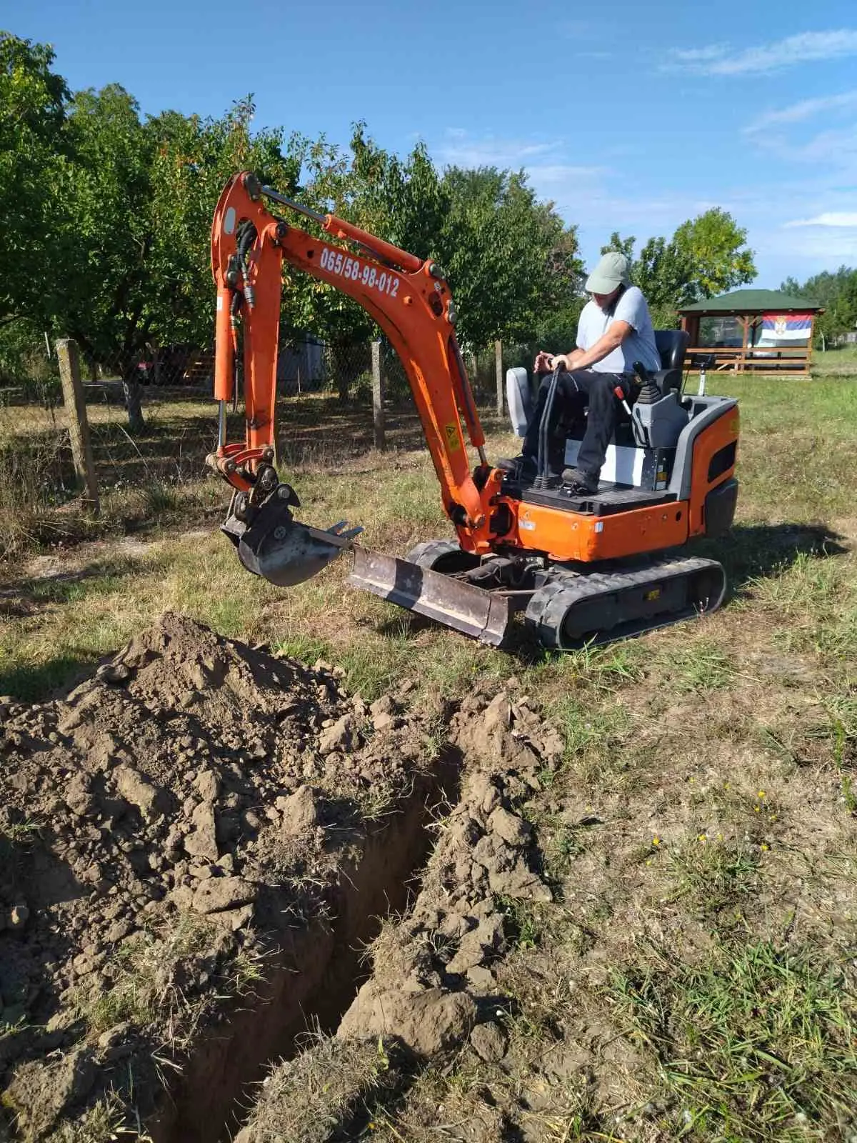 Operater kopa kanal mini bagerom 021 Alfa Sistem na otvorenoj parceli